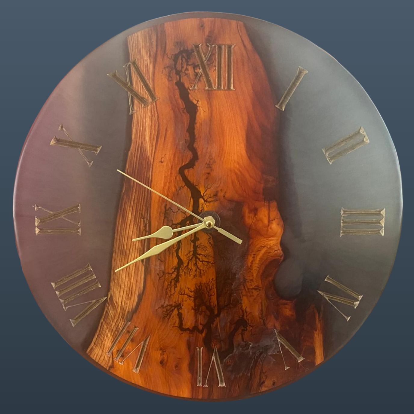 Round wall clock with a live-edge wood grain design in warm brown and orange tones, Roman numeral hour markers, and gold-tone hands.